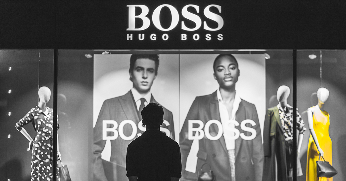 Etalage van het kledingmerk HUGO BOSS in de achtergrond met ervoor een potentiële klant die er naar kijkt.