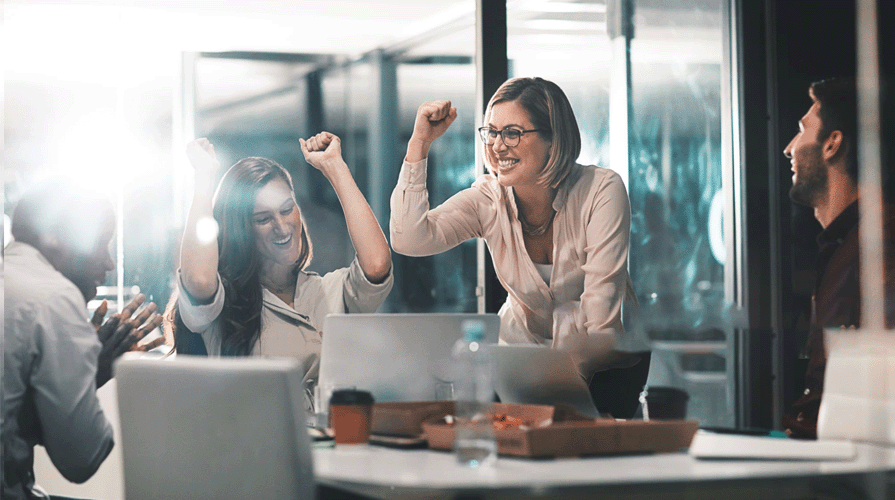 Kantoormedewerkers die achter een laptop juichen om een overwinning. Mogelijk om de optimalisatie van conversie.